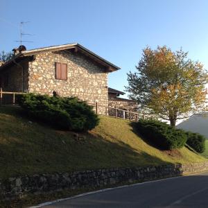 ein Steinhaus auf einem Grashügel in der Unterkunft Mirabilia in Adrara San Rocco