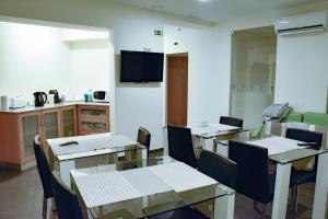 a dining room with tables and chairs and a kitchen at Casa Salomão in Termas de Sao Pedro do Sul