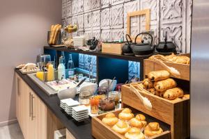 - une boulangerie avec du pain et des viennoiseries sur un comptoir dans l'établissement Campanile Annecy Centre - Gare, à Annecy