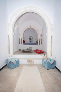 a room with an archway in a white room at Dar Tenast in Houmt Souk