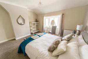 a bedroom with a large white bed and a window at Hallam Lodge in Nelson