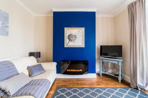 a living room with a blue wall and a fireplace at Hallam Lodge in Nelson