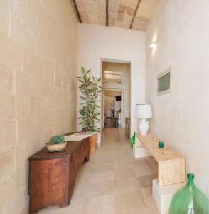 un pasillo con bancos, una mesa y una lámpara en Balbo - Suite & Apartment SIT, en Lecce