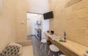 a kitchen and living room with a counter and stools at Balbo - Suite & Apartment SIT in Lecce