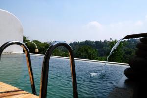a person pouring water into a swimming pool at Boscha Villas 101 in Bandung