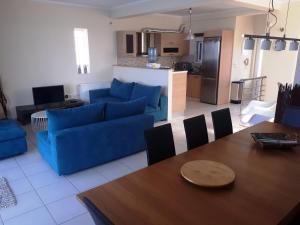 uma sala de estar com um sofá azul e uma mesa em Vrachati Sea Front House em Káto Ássos