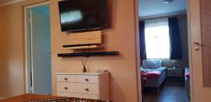 Habitación con TV en la pared y tocador en Holiday house in Lofoten, en Kabelvåg