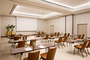 a classroom with tables and chairs and a whiteboard at Starhotels Tourist in Milan