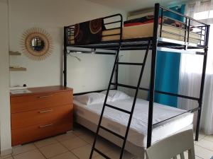 a bedroom with two bunk beds and a dresser at Studio Pitaya in Les Trois-Îlets