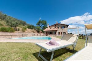 un sombrero sentado en una silla junto a una piscina en Agriturismo Molino Verde, en Montecchio