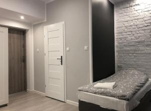 a bedroom with a bed and a brick wall at Aparthotel 11 in Kwidzyn