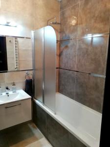 y baño con ducha y lavamanos. en SOSNOWA Apartament en Ełk