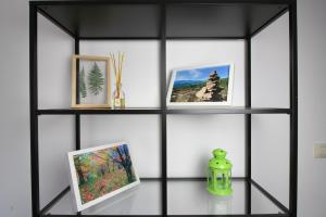 a black shelf with pictures and a vase on a table at El Arrecorzo by #cherrygredos in El Arenal