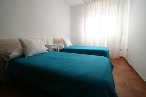 een slaapkamer met twee bedden en een raam bij El Arrecorzo by #cherrygredos in El Arenal