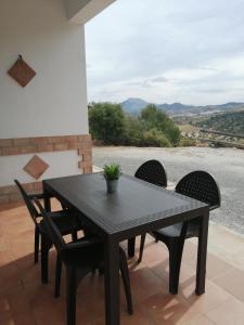 einen schwarzen Tisch und Stühle auf einer Terrasse in der Unterkunft La Solana de turón. La coscoja. in Ardales
