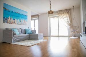 ein Wohnzimmer mit einem Sofa und einem großen Fenster in der Unterkunft Bay View Apartment in Porto Torres