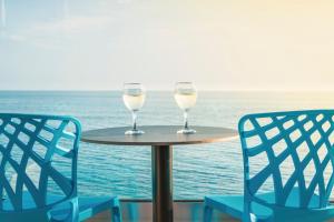 ヒマラにあるARXONTIKOの海の前のテーブルに座るワイン2杯