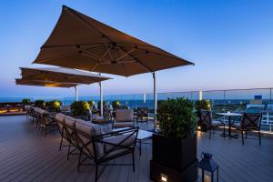 a deck with tables and chairs and umbrellas at Hyatt Regency Tokyo Bay in Urayasu