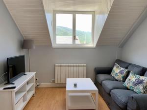 sala de estar con sofá y ventana en BPIRINEOS-Blest, en Benasque