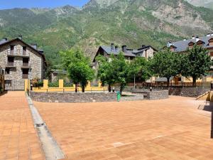 a courtyard with houses and trees and a mountain at BPIRINEOS-Blest in Benasque