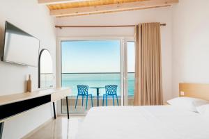 a bedroom with a bed and a view of the ocean at ARXONTIKO in Himare