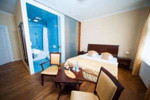 a hotel room with a bed and a table and chairs at Hotel zum Hofmaler in Potsdam