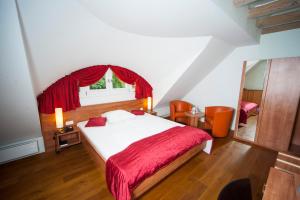 a bedroom with a bed with a red blanket and a window at Hotel zum Hofmaler in Potsdam