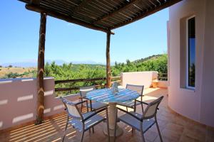 a patio with a table and chairs on a balcony at Listaros Villas in Lístaros