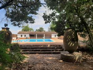 une villa avec une piscine et une statue dans l'établissement Quinta do Caçador, à Estremoz