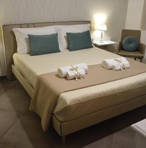 a bedroom with a large bed with towels on it at ZI DIMA APARTMENTS in Giardini Naxos