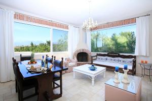 a living room with a table and a fireplace at Listaros Villas in Lístaros