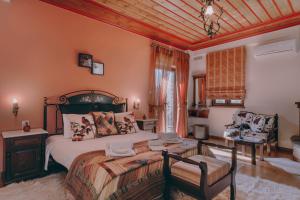 a bedroom with a bed and a table and a chair at Etheres Tzoumerkon Mountain Resort in Katarráktis