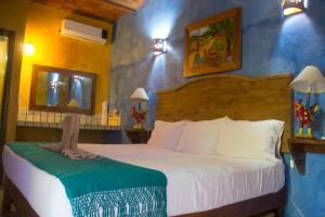 a bedroom with a bed with a large white bed sidx sidx sidx at Cabañas del Capitan in Rincon de Guayabitos