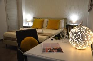 Sala de estar con cama y mesa con lámpara en ZI DIMA APARTMENTS, en Giardini Naxos