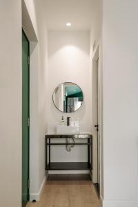 ein Bad mit einem Waschbecken und einem Spiegel in der Unterkunft Botanist Lab Minihotel by CIRCADIAN in Ho-Chi-Minh-Stadt