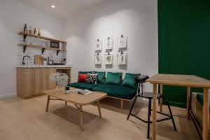 ein Wohnzimmer mit einem grünen Sofa und einem Tisch in der Unterkunft Botanist Lab Minihotel by CIRCADIAN in Ho-Chi-Minh-Stadt