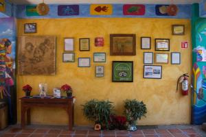 a yellow wall with a table and pictures on it at Cabañas del Capitan in Rincon de Guayabitos