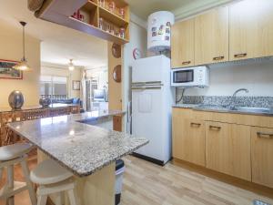 uma cozinha com um frigorífico branco e uma bancada em TarracoHomes, Beach apartment cambrils em Cambrils