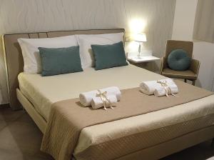 a bedroom with a bed with towels on it at ZI DIMA APARTMENTS in Giardini Naxos