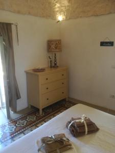 ein Schlafzimmer mit einem Bett und einer Kommode mit zwei Taschen darauf in der Unterkunft Trullo Nonna Mari in Cisternino