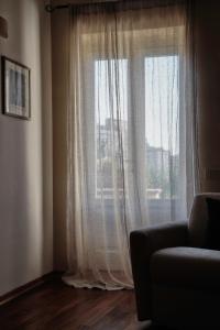 a living room with a large window with white curtains at Il Giardino di Eleonora in Matera