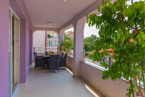 a balcony with a table and chairs and windows at Apartments Ankica in Crikvenica