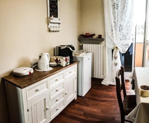 een keuken met witte kasten en een aanrecht bij ACERO ROSSO in Pianfei