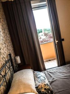 a bedroom with a bed in front of a window at ACERO ROSSO in Pianfei