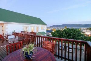 a balcony with a table and chairs on a deck at Knysna Manor House in Knysna