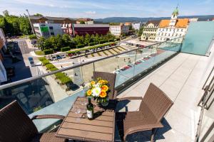 a table and chairs on a balcony with a view of a city at Rezidence Fontána in Teplice