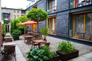 an outdoor patio with tables and chairs and plants at Hotel zum Hofmaler in Potsdam