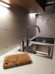 a kitchen counter with a sink and a cutting board at MAPLE place in Pivka