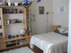 a bedroom with a bed and a book shelf with books at Kotimajoitus Hella Härmä in Kauhava