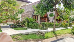 une maison avec un arbre en face dans l'établissement Salili Bungalow, à Gili Air